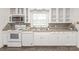 Well-lit kitchen boasts white cabinetry, stainless steel microwave, and sleek granite countertops at 1320 Hartford Ave, Charlotte, NC 28209
