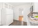 Classic white kitchen with white appliances, granite countertops, and view to adjacent room at 1320 Hartford Ave, Charlotte, NC 28209