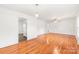 Open-concept living area with gleaming hardwood floors, neutral paint, and easy access to kitchen at 1320 Hartford Ave, Charlotte, NC 28209
