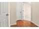 Hallway has hardwood floors transitioning to carpet, neutral paint, and multiple doors providing access to various rooms at 14853 Santa Lucia Dr, Charlotte, NC 28277