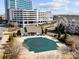Aerial view of a community pool with a protective green cover, surrounded by buildings in a landscaped environment at 14853 Santa Lucia Dr, Charlotte, NC 28277
