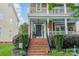 Inviting home entrance with a red brick stairway, a beautiful floral wreath, and lush green landscaping at 16425 Spruell St, Huntersville, NC 28078