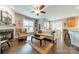Spacious living room with hardwood floors that flows into dining area, a fireplace, and abundant natural light, perfect for entertaining at 16425 Spruell St, Huntersville, NC 28078