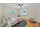 Bright bedroom with hardwood floors, two windows, a ceiling fan, and space for a  at 1770 Nc 90 W Hwy, Taylorsville, NC 28681