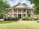 Elegant brick home with white columns, second story balcony, and manicured front lawn at 18419 Dembridge Dr, Davidson, NC 28036