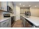 Modern kitchen with stainless appliances, white countertops, and gray cabinets at 1983 Paddlewheel Dr, Stanley, NC 28164