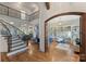 Elegant foyer featuring hardwood floors, a grand staircase, and an arched doorway to an office at 2004 Garden View Ln, Weddington, NC 28104