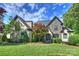 Stunning stone and stucco home with manicured lawn and mature trees, showcasing curb appeal at 2004 Garden View Ln, Weddington, NC 28104