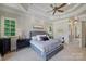 Serene primary bedroom with tray ceiling, plush carpet, and ample natural light from windows at 2004 Garden View Ln, Weddington, NC 28104