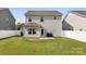 View of backyard featuring a gray two-story home with a well-maintained lawn and white fence at 2104 New Hope Branch Way, Belmont, NC 28012