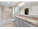 Bright bathroom featuring double vanity with granite countertop, tiled shower with glass door, and walk-in closet at 2104 New Hope Branch Way, Belmont, NC 28012