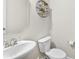 Clean half bathroom featuring a modern sink and toilet, complemented by decorative wall accents at 2104 New Hope Branch Way, Belmont, NC 28012