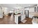 Open-concept kitchen with stainless steel appliances, white cabinets, and a kitchen island overlooking the living area at 2104 New Hope Branch Way, Belmont, NC 28012