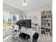 Bright office space featuring a large desk, dual monitors, and built-in shelving for organized storage at 2104 New Hope Branch Way, Belmont, NC 28012