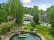 Scenic aerial view of waterfront property with dock, swimming pool, and landscaping at 21404 Blakely Shores Dr, Cornelius, NC 28031