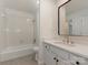 White tiled bathroom featuring white cabinets, white sink top, and bathtub with shower at 21404 Blakely Shores Dr, Cornelius, NC 28031
