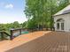 Expansive wooden deck overlooking a serene pool and lake, perfect for outdoor entertaining and relaxation at 21404 Blakely Shores Dr, Cornelius, NC 28031