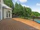 Spacious wooden deck overlooking a swimming pool and lush green trees, perfect for outdoor relaxation at 21404 Blakely Shores Dr, Cornelius, NC 28031