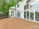 Stunning home featuring a large wooden deck, expansive windows, and lush green surroundings at 21404 Blakely Shores Dr, Cornelius, NC 28031