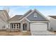 Charming single-Gathering home with blue siding, stone accents, and a two-car garage at 219 Tillery Ln # 755, Mount Gilead, NC 27306