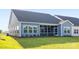 Back exterior of a gray home showing backyard with green grass and screened porch at 219 Tillery Ln # 755, Mount Gilead, NC 27306