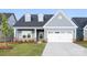 Charming single-story home featuring light blue siding, dormer windows, green front door and a two-car garage at 219 Tillery Ln # 755, Mount Gilead, NC 27306