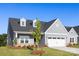 Charming single-story home featuring light blue siding, dormer windows, green front door and a two-car garage at 219 Tillery Ln # 755, Mount Gilead, NC 27306