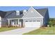 Charming single-story home featuring light blue siding, dormer windows, green front door and a two-car garage at 219 Tillery Ln # 755, Mount Gilead, NC 27306
