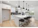 Modern kitchen features a large island with seating, white cabinets, stainless steel appliances, and stylish pendant lighting at 219 Tillery Ln # 755, Mount Gilead, NC 27306