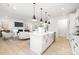 Open-concept kitchen with white cabinets, a large island, pendant lighting, seamlessly connected to the living area at 219 Tillery Ln # 755, Mount Gilead, NC 27306