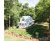 Gorgeous home with bright white exterior, complemented by green lawns and natural landscaping and mature trees at 2268 New Gray Rock Rd, Fort Mill, SC 29708