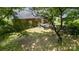 Overhead shot of the backyard of a brick home, featuring a cozy deck and mature shade trees at 2324 Knight Dr, Gastonia, NC 28052