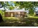 View of the backyard featuring a wooden deck, grassy area, and shady mature tree at 2324 Knight Dr, Gastonia, NC 28052