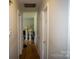 A hallway featuring neutral walls, hardwood floors, and closed doors at 2324 Knight Dr, Gastonia, NC 28052