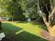 Large backyard with lush green grass, mature trees, and a storage shed, providing ample space for outdoor activities at 2469 Elkwood Cir, Charlotte, NC 28205