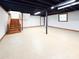 Bright basement space with painted ceiling, painted walls, garage door, window and stairs at 2469 Elkwood Cir, Charlotte, NC 28205