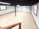 Large basement space with garage door, painted ceiling, painted walls, and window at 2469 Elkwood Cir, Charlotte, NC 28205