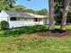 Well-maintained single-story home with a green lawn and mature trees at 2469 Elkwood Cir, Charlotte, NC 28205