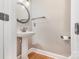 Compact bathroom with a pedestal sink, round mirror, and modern fixtures at 3906 Balsam St, Indian Trail, NC 28079