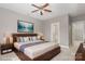 Staged main bedroom includes a ceiling fan, art piece and window at 3906 Balsam St, Indian Trail, NC 28079