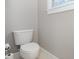 Powder room has a simple toilet and neutral colored walls at 3906 Balsam St, Indian Trail, NC 28079