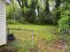 A spacious backyard with lush greenery and an open view through an aged metal fence at 415 Orange St, Shelby, NC 28150