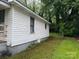 Side exterior view of a home with white siding and a small window, alongside a green lawn at 415 Orange St, Shelby, NC 28150