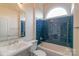 Bathroom with blue tile, white fixtures, and arched window at 416 E Park Ave, Charlotte, NC 28203