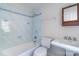 Bathroom features a bathtub with shower, a sink with silver hardware, and stylish blue tiling at 416 E Park Ave, Charlotte, NC 28203