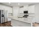 Modern kitchen features an island with a granite countertop, white cabinets, and stainless steel appliances at 417 Bent Burr Crk, York, SC 29745