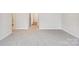 Neutral living room with carpet floors, white trim, and three doorways leading to other rooms at 417 Bent Burr Crk, York, SC 29745