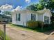 The side exterior view of a white home with green shutters and a matching green roof at 447 17Th St, Cramerton, NC 28032