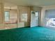 Inviting living room with green carpet, partial wall partition, and sunlit windows at 447 17Th St, Cramerton, NC 28032