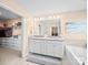 Bathroom featuring a double vanity with white cabinets, a large mirror, and a walk-in closet at 5062 Gribble Ln, Lancaster, SC 29720